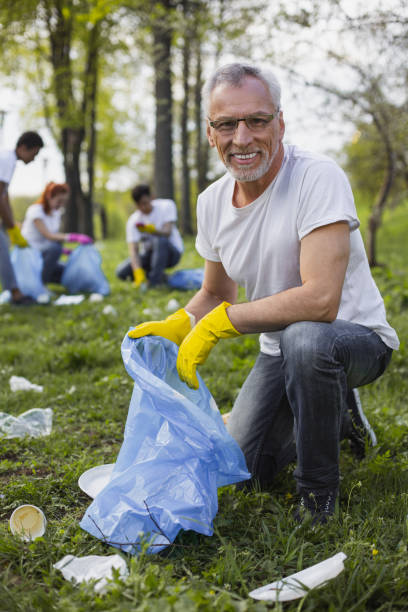 istock Gay senior volunteer cleaning park 968871904