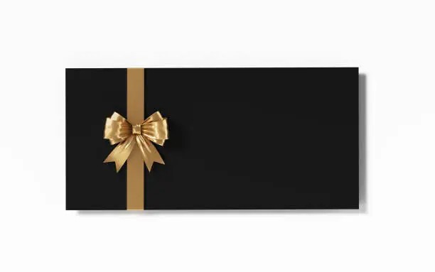 Black gift card with gold colored bow tie on white background. Horizontal composition with clipping path and copy space.