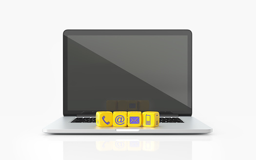 Yellow toy blocks with various contact us symbols on a laptop over white background. Contact us concept. Horizontal composition with copy space. Front view.