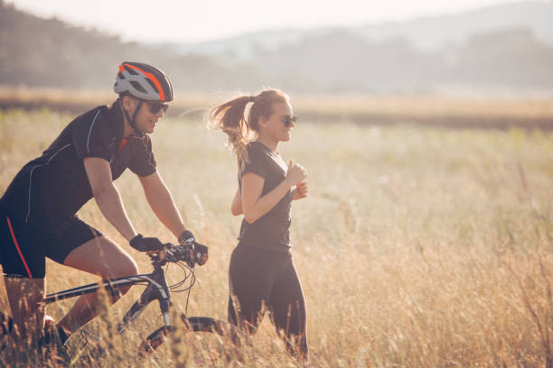istock Friends running and cycling through meadow 968874952