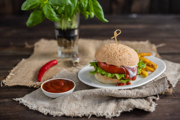 istock Tasty hamburger with meat and vegetables against a dark background 968878608