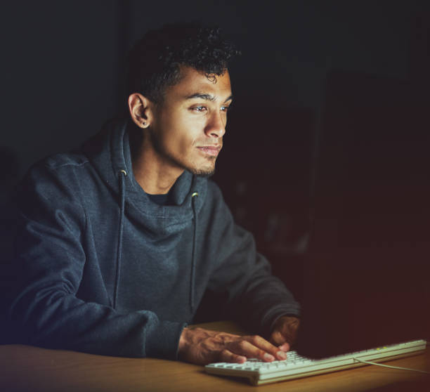istock Working late, a young man stares at his computer monitor 968879480