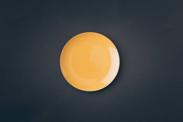 istock top view of yellow plate on gray table 968881724