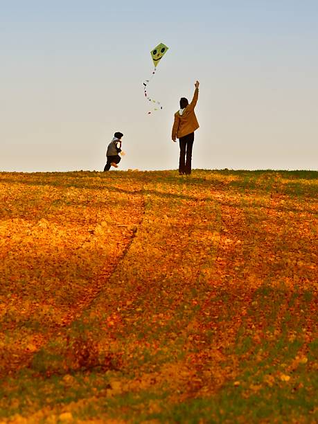 Mother and son on autumn fly a kite.