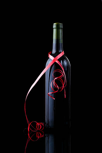 Bottle of  wine wrapped in a red ribbon stock photo