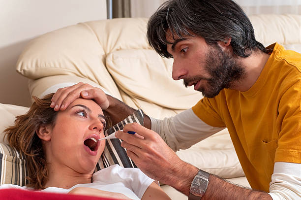 Man Checks a Woman's Temperature stock photo