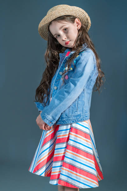 istock Little Girl in Straw Hat Is Posing in Half Turn to Camera 968902988
