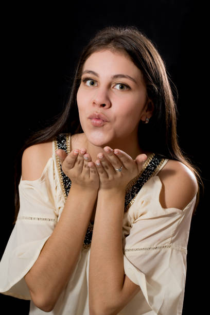 istock Young Lady Studio Portrait Blowing a Kiss 968907270