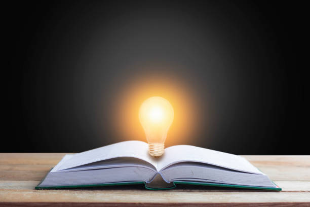 istock Knowledge , idea and education concept, book opening with light bulb on black background 968907282