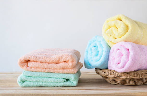 istock towel on basket on wood table with white wall and copy space, can be used for present products 968907346