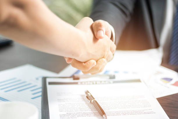 istock Two businessmen shaking hand after successful negotiate and signing on contract about working and partner together. 968907366