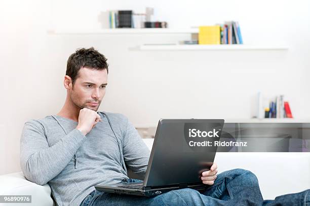 Man Working On His Laptop In A White Living Room Stock Photo - Download Image Now - Examining, Home Interior, Men