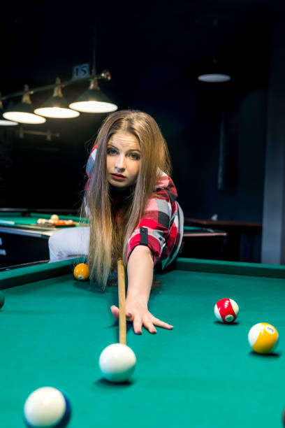 istock Woman going hit a ball with cue in billiard 968910356