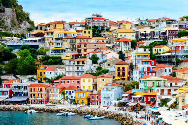 Parga in Greece Panoramic view of the landscape and town from the public beach. Focus on colorful houses and restaurants with the clear turquoise sea in the foreground. parga greece stock pictures, royalty-free photos & images