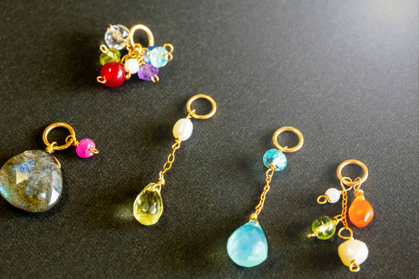 istock lemon quartz, ruby, pearl,labradorite,apatite, green chalcedony, blue topaz necklace charm isolated on black background. 968911334