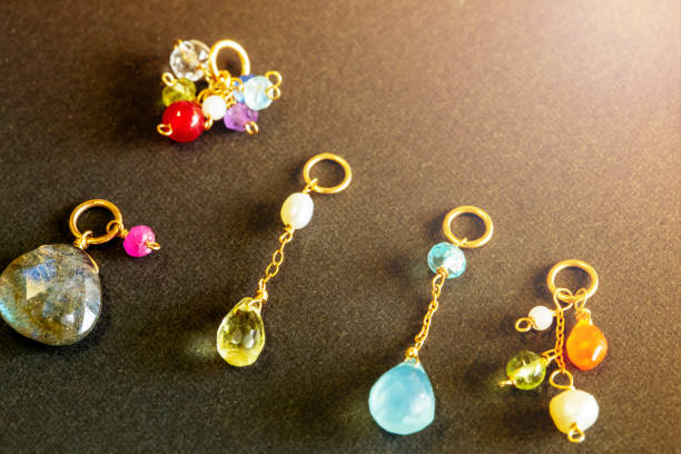 istock lemon quartz, ruby, pearl,labradorite,apatite, green chalcedony, blue topaz necklace charm isolated on black background. 968911384