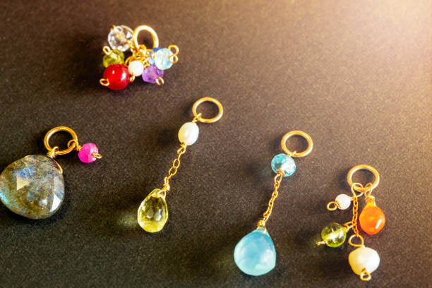 istock lemon quartz, ruby, pearl,labradorite,apatite, green chalcedony, blue topaz necklace charm isolated on black background. 968913496