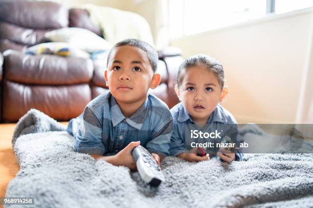 Two Brothers Lying Down And Watching Tv Stock Photo - Download Image Now - Watching TV, Child, New Zealand