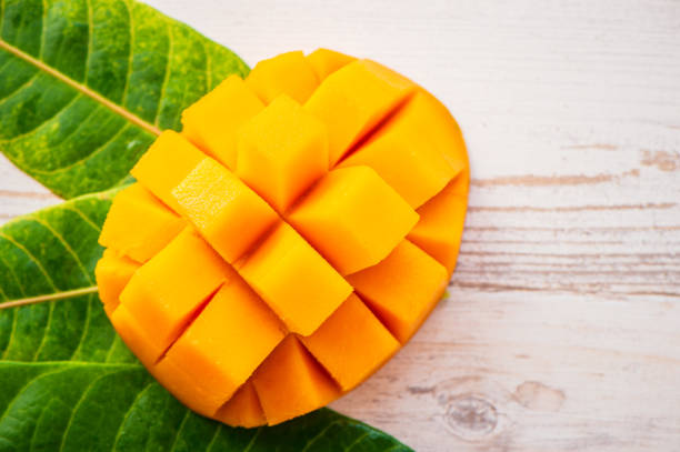 istock Fresh and beautiful mango fruit with sliced diced mango chunks on a light wooden background, copy space(text space), blank for text, top view. 968914676