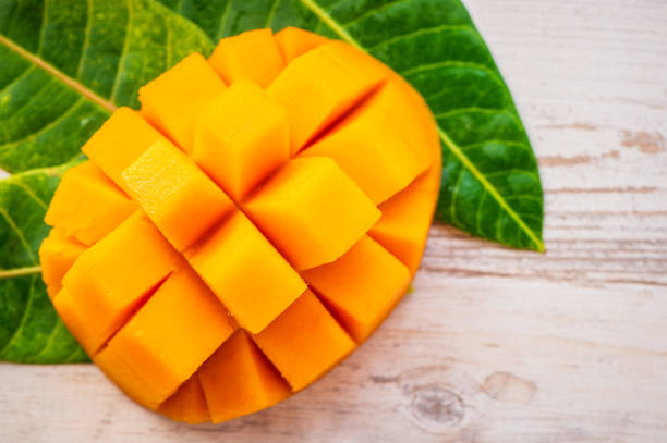 istock Fresh and beautiful mango fruit with sliced diced mango chunks on a light wooden background, copy space(text space), blank for text, top view. 968914726