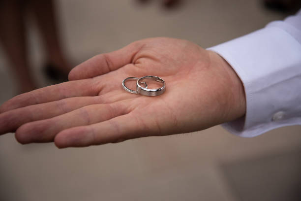 istock Wedding rings sitting on the palm of a mans hand 968917896
