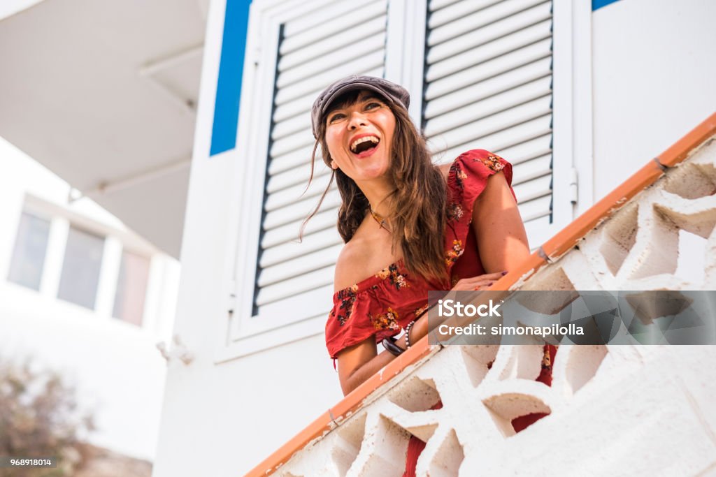 grand sourire et rire de bonheur et d’apprécier le concept avec un peuple caucasien belle de 40 ans avec des maisons blanches dans le fond. saison de belle activité de loisirs pour femme fashion et sexy modèle - Photo de 45-49 ans libre de droits