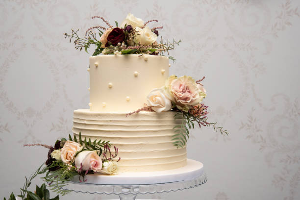 Champagne wedding cake with yellow and pink flower arrangements Champagne wedding cake with yellow and pink flower arrangements wedding cake stock pictures, royalty-free photos & images