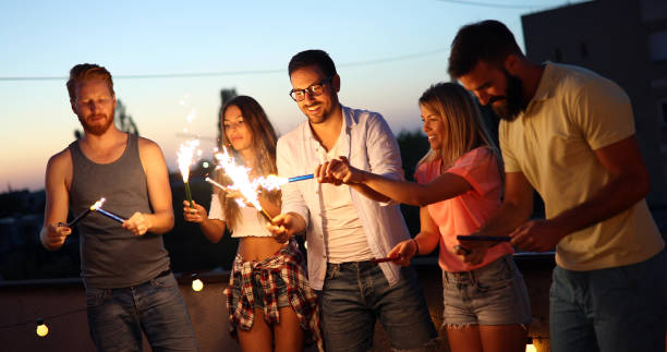 istock Friends enjoying a rooftop party and dancing with sparklers 968920442