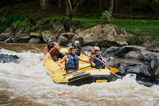 Shot of a group of young male friends white water rafting