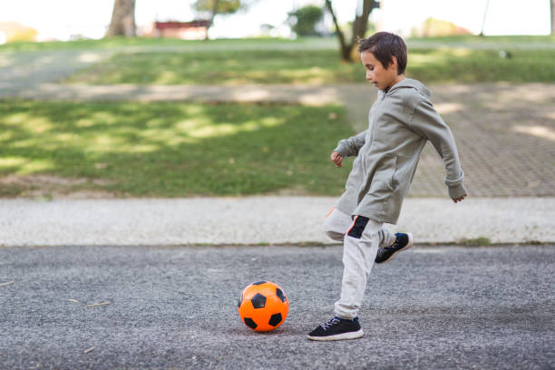 istock Boy play with football ball 968925208