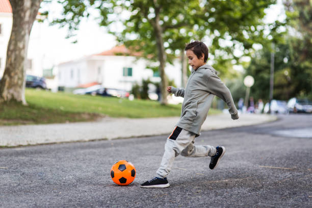 istock Boy play with football ball 968925212