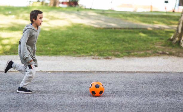 istock Boy play with football ball 968925214