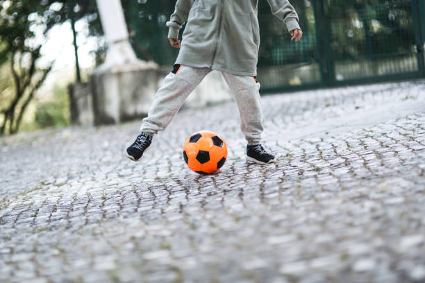 istock Boy play with football ball 968925236