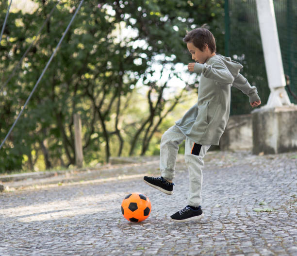 istock Boy play with football ball 968925238
