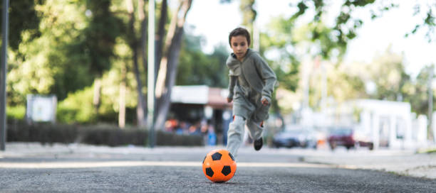 istock Boy play with football ball 968925260