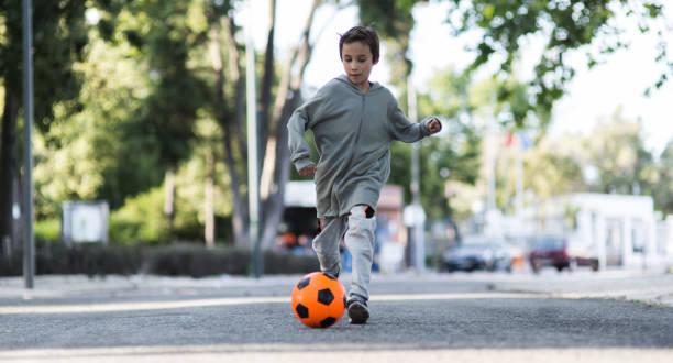 istock Boy play with football ball 968925266