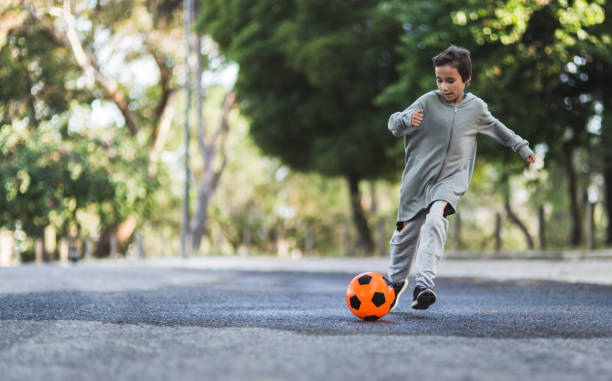 istock Boy play with football ball 968925274