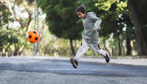 istock Boy play with football ball 968925284
