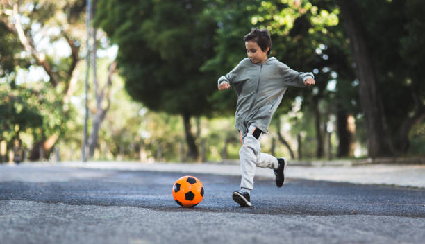 istock Boy play with football ball 968925294