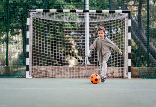 istock Boy play with football ball 968925376