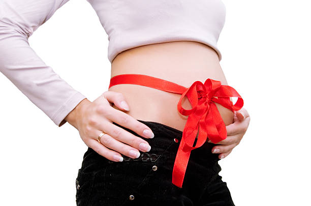istock Pregnant woman's belly with red ribbon around 96893448