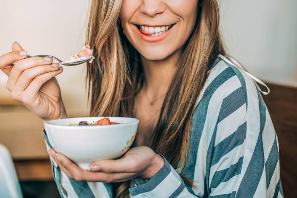 crop woman da vicino mangiando avena e ciotola di frutta per colazione - oatmeal porridge bowl spoon foto e immagini stock