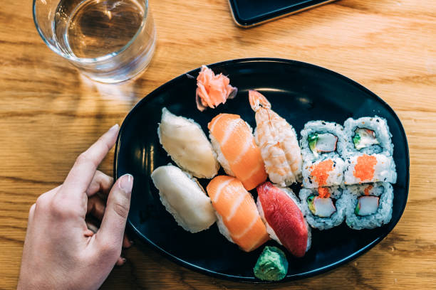 istock Crop woman eating sushi 968935196