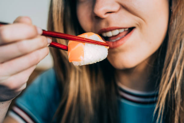 istock Crop woman eating sushi 968935214
