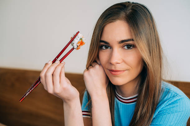 istock Crop woman eating sushi 968935236