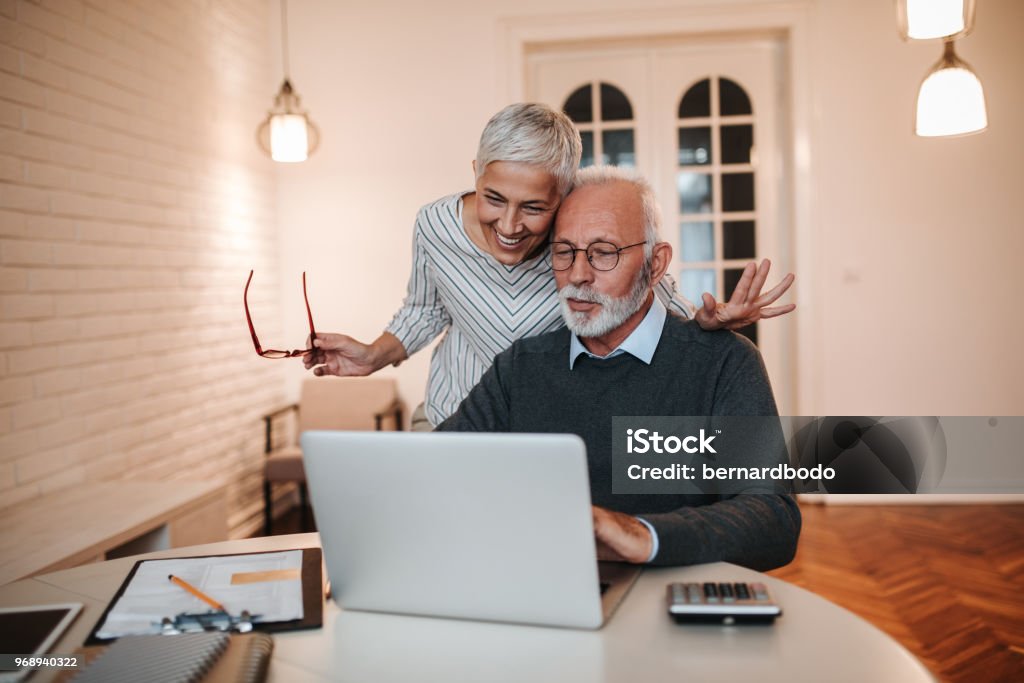 Great news ! Senior couple looking at a laptop computer Senior Adult Stock Photo