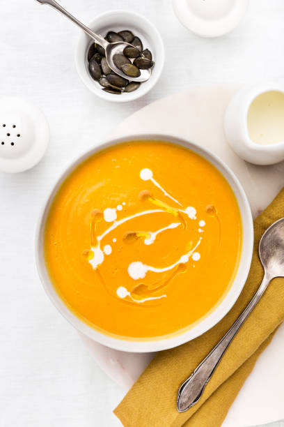 istock Pumpkin creamy soup decorated with fresh cream 968940956