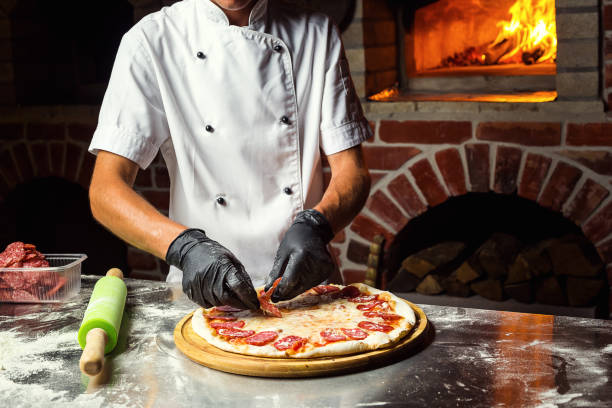 istock Cook (Chef) making delicious pizza at the restaurant, close-up 968941128