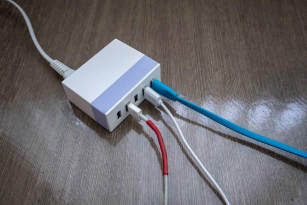 スマート フォンやタブレット木質系床のマルチポート usb 電源アダプター充電 - mobile phone charging power plug adapter ストックフォトと画像