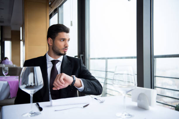 istock portrait of man in suit looking out window while sitting at served table in restaurant 968953300